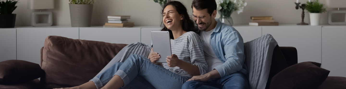Banner com um casal feliz olhando para um tablet e o logo da Luz
